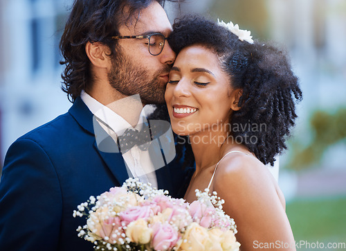 Image of Care, kiss and couple at wedding happy with romantic outdoor marriage event celebration with flowers. Partnership, commitment and trust embrace of interracial bride and groom with excited smile.