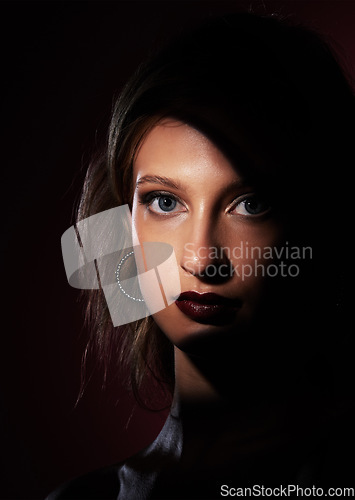 Image of Portrait, beauty and makeup with a model woman in studio on a dark background for fashion or cosmetics. Face, light and glamour with an attractive young female posing on black space for style