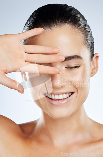 Image of Face, beauty and skincare of a woman in studio with a smile for natural cosmetic product. Happy aesthetic model person show hand for makeup, facial and dermatology for skin glow and spa wellness