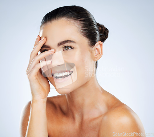 Image of Beauty, skincare and hand on face of a woman in studio with a smile for natural cosmetic product. Aesthetic model person happy about makeup, facial and dermatology for skin glow and spa wellness