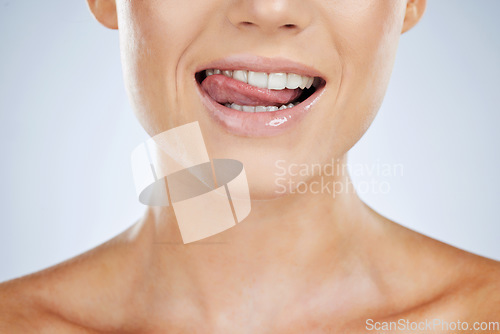 Image of Woman, closeup and smile with tongue in studio for beauty, skincare and face by grey by background. Model, healthy mouth and teeth whitening with dental wellness, health and self care for aesthetic