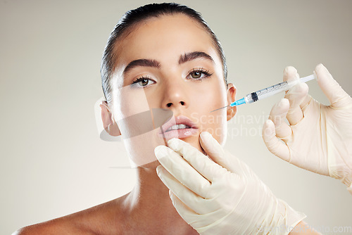 Image of Skincare, collagen and portrait of woman with injection in lips from healthcare professional, anti aging treatment in studio. Beauty, model and aesthetic facial lip filler syringe on background