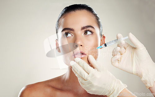 Image of Skincare, aesthetic beauty and woman with injection in lips from healthcare professional, anti aging treatment in studio. Collagen, mouth and model with facial lip filler syringe on white background.