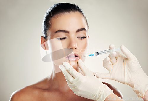 Image of Skincare, collagen and aesthetic beauty, woman with injection in lips and treatment from healthcare professional. Mouth, needle and model with facial lip filler syringe on white background in studio