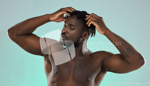 Image of Dreadlocks hair, shirtless man and studio for beauty, self care and cosmetic wellness by blue background. African gen z model, muscle and strong body with hands on head and scalp massage