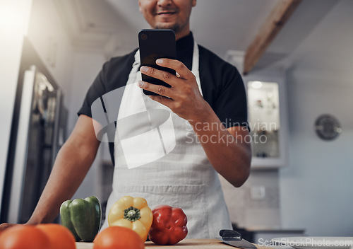 Image of Cooking vegetables, phone and man in kitchen while online with house wifi connection for learning on food blog. Chef person with mobile app for online recipe for home food for vegan or healthy eating