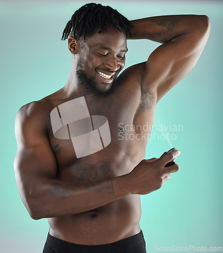 Image of Black man, deodorant body spray and studio with smile for hygiene, clean and fresh fragrance by blue background. Happy gen z model, African and product for healthy underarm skin in hand for wellness