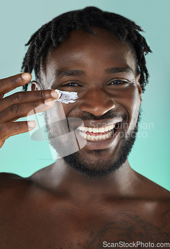 Image of Skincare, wellness and black man with face cream in a studio with a beauty, health and natural skin routine. Portrait, cosmetic and African guy with facial spf, lotion or creme by a blue background.