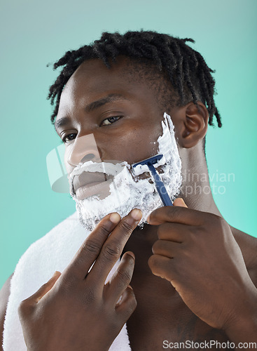 Image of Shaving face with skincare cream, black man with razor on studio background and on smooth facial hair growth. Confident young model grooming, body hygiene and cleaning beard with cosmetic product