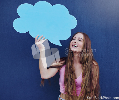 Image of Happy woman holding a chat board with mockup space standing by a blue wall with a sign. Gen z, happiness and young female with a speech bubble with mock up or copy space for marketing or advertising.