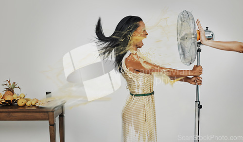 Image of Art, juice and summer splash, woman with refreshing wind in face from fan and fruit for cocktail drinks. Air con, heat and fresh squeezed orange spray blowing with scream in creative advertisement.
