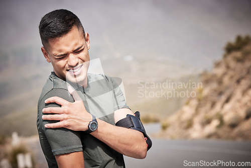 Image of Fitness, injury and mockup with a sports man holding his shoulder in pain while running outdoor. Medical, exercise and anatomy with a male runner or athlete suffering from a hurt joint while training