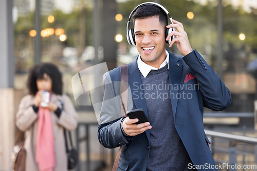 Image of Phone, headphones and businessman walking in the city while listening to music, radio or podcast. Happy, smile and portrait of a professional corporate male commuting to work in the town street.