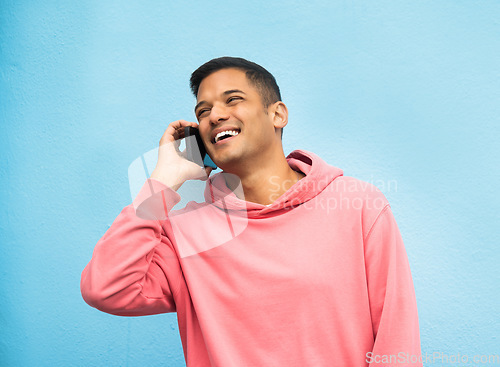 Image of Casual man, phone call and laughing in communication standing isolated on a blue background. Happy male, person or guys with pink jacket in discussion, conversation or talking on mobile smartphone