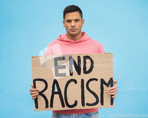 Image of Portrait, sign and racism with a man in studio on a blue background for freedom at a march or rally. Government, politics and justice with a male protestor holding a for protest or equality