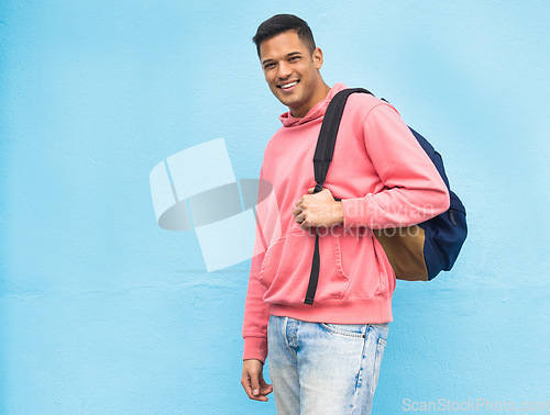 Image of Portrait, university and man student with backpack in studio, happy and smile on blue background. Face, handsome and college student excited about education, vision and career goal while isolated