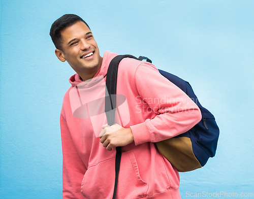 Image of Man, backpack and university student happy in studio, laughing and smile on blue background. Young, handsome and college student excited for education, vision and career goal while standing isolated