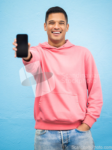 Image of Happy man, portrait or phone screen mockup on isolated blue background for social media, app or web design. Smile, student or model with technology mock up for city contact communication or branding