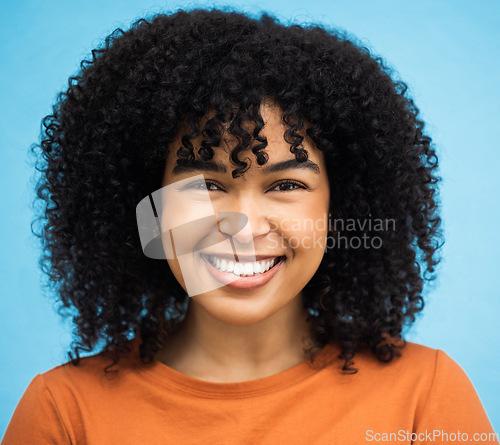 Image of Happy, black woman or afro hairstyle portrait on isolated blue background in keratin treatment, self love or healthcare wellness. Headshot, smile or beauty model and curly brunette on urban city wall