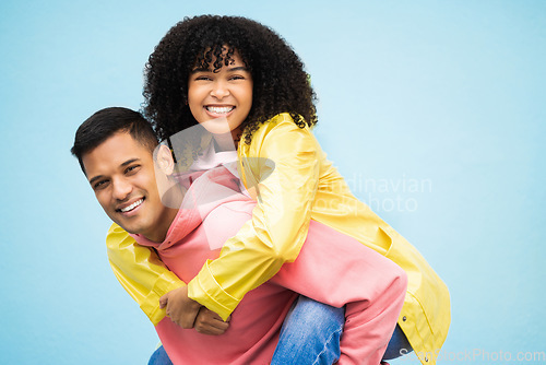 Image of Happy people, bonding and piggyback portrait on isolated blue background in travel, date or fun game. Smile, man and carrying black woman in playful, silly or goofy trust for love couple in support