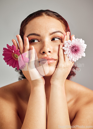 Image of Woman, studio and face with flowers for thinking, beauty or healthy skincare for natural spring aesthetic by background. Model, girl and carnation plant for cosmetic health, skin glow or eco friendly