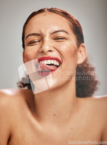 Image of Beauty, face and woman, lipstick and makeup with tongue out and teeth, skin and happy isolated on studio background. Crazy, flirt and red lips with skincare and glow from cosmetic care and portrait