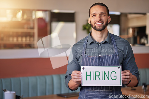 Image of Recruitment, portrait or man with a hiring sign for job vacancy offer in cafe or small business store. Hospitality, labour shortage or happy entrepreneur smile with an onboarding message to hire