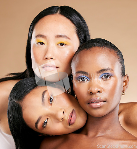 Image of Diversity, woman and focus face with makeup, skincare beauty and cosmetics dermatology in brown background studio. Interracial models, facial care and support together for natural glowing skin