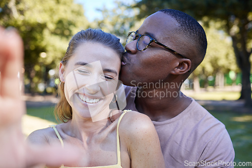 Image of Love, kiss and selfie with interracial couple at park for relax, social media and romantic date. Support, happiness and quality time with black man and woman in nature for bonding, calm and vacation