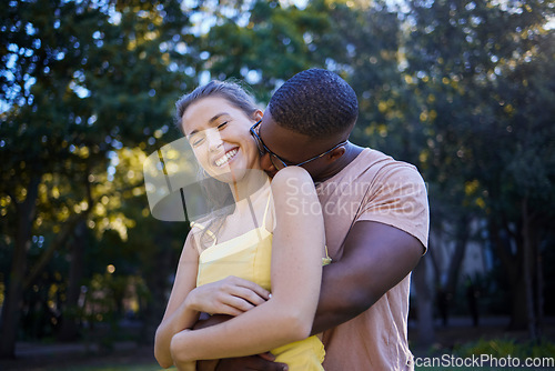 Image of Couple, date in park with hug and outdoor in nature, love and commitment with interracial relationship. Trust, support and happy people, black man and woman smile on face with fresh air with partner