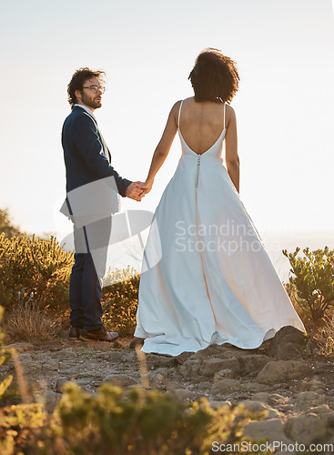 Image of Wedding, nature or a couple of friends holding hands on a mountain in a romantic celebration of love. Interracial marriage, black woman and happy man in a commitment as bride and groom at sunset