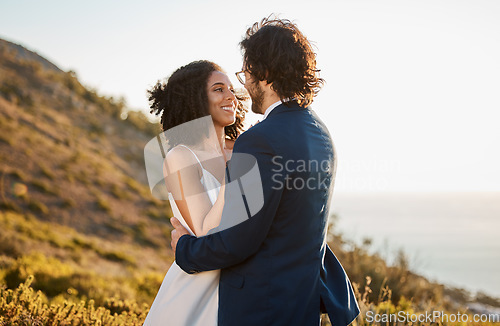 Image of Marriage, love and bride with groom on mountain for wedding ceremony, commitment and celebration. Romance, happiness and interracial couple bonding, hug and smile with ocean, nature and outdoors