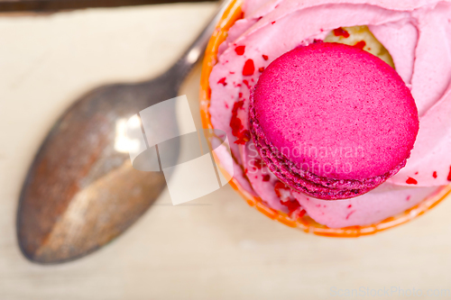 Image of pink berry cream cupcake with macaroon on top