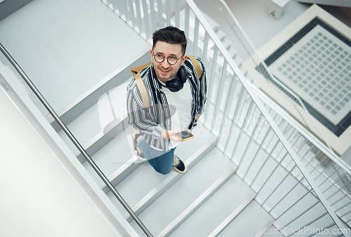 Image of Happy, student or startup man with phone on staircase for internet research, social media content or networking. Smile, top or employee nerd on smartphone for strategy, blog review or communication