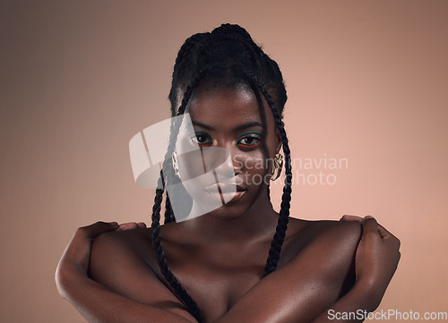 Image of Portrait, hair and braids with a model black woman in studio on a wall background for natural haircare. Face, beauty and makeup with an attractive young female posing to promote cosmetics