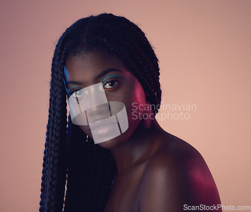 Image of Portrait, face and hair with a model black woman in studio on a wall background for natural haircare. Makeup, beauty and braids with an attractive young female posing to promote keratin treatment