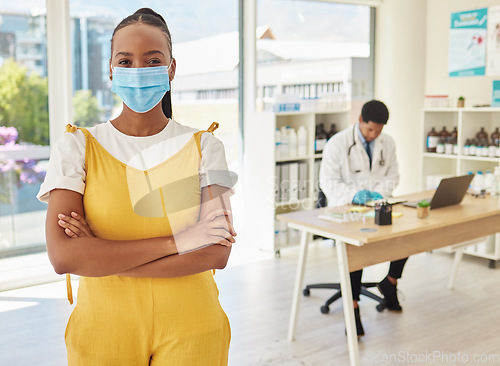 Image of Portrait, covid and healthcare with a black woman patient in a hospital standing arms crossed for her vaccination. Vaccine, mask and medical with a female in a clinic for heakth, cure or treatment