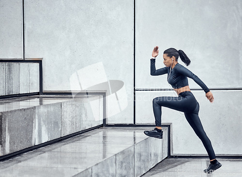 Image of Fitness, training and woman running on stairs for health, cardio and morning workout in the city. Focus, commitment and athlete doing exercise on steps for sports, motivation and sprinting in France