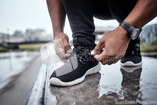 Image of Fitness, shoes and running with a sports man tying his laces for an outdoor cardio or endurance workout. Exercise, footwear and training with a male athlete or runner fastening his shoelaces outside