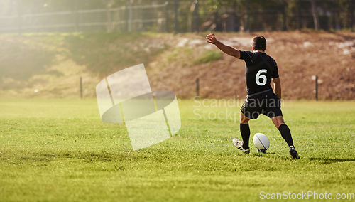 Image of Rugby, player and kick a sports ball on a field during practice, exercise or training outdoors. Athlete, sportsman and man during a game taking a penalty for a championship match on summer day