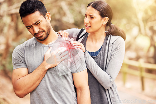 Image of Fitness, pain and injury with a woman massaging the shoulder of her boyfriend while running outdoor. Exercise, medical and hurt joint with a couple training outside during a workout for health