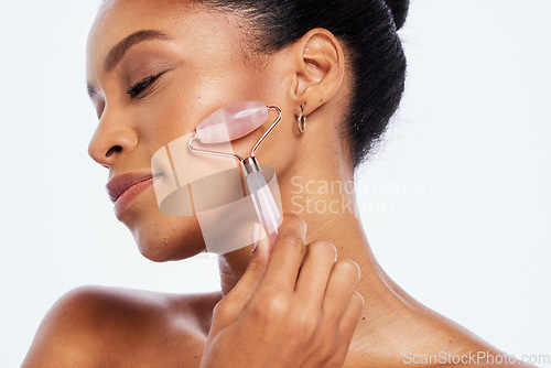 Image of Facial roller, beauty and face of a woman in studio for dermatology, cosmetics and natural skin. Aesthetic model person with facial massage tools for healthy glow isolated on a white background