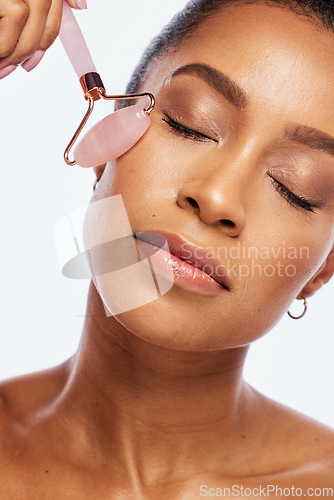 Image of Jade roller, beauty and facial massage for a woman in studio for dermatology, cosmetic and natural face. Aesthetic model person with spa derma stone for healthy glow isolated on a white background