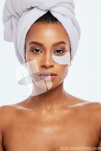 Image of Skin care, eye patch and beauty portrait of a woman in studio for dermatology and cosmetics. Aesthetic model person for spa facial, towel and healthy or natural face glow isolated on white background