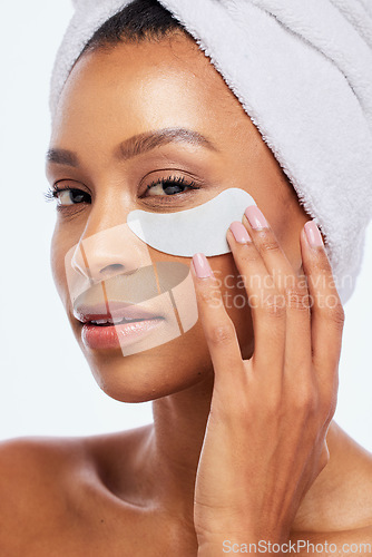 Image of Spa eye patch, skincare and beauty of a woman portrait in studio for dermatology. Aesthetic model for spa facial, towel and healthy or natural face glow, hand on cosmetic isolated on white background