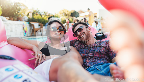 Image of Couple, relax and smile for pool party on inflatable floating in the water enjoying summer vacation together. Happy man and woman relaxing in swimming pool on floaty with sunglasses for holiday break