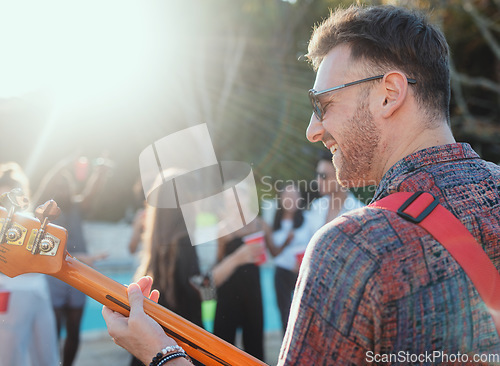 Image of Guitar, music and party with a man outdoor at a celebration playing a song as a musician or artist. Happy, fun and performance with a male guitarist holding an instrument to perform at a birthday