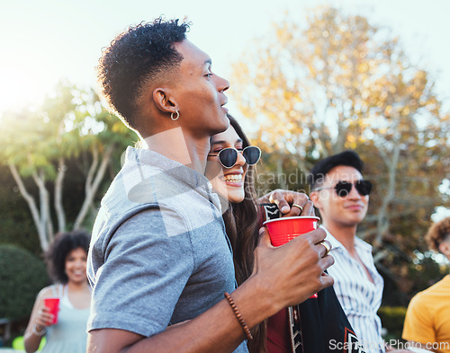 Image of Drinks, party and a couple of friends outdoor to celebrate at festival, concert or summer social event. Diversity young men and women crowd while happy, hug and drinking alcohol while listening