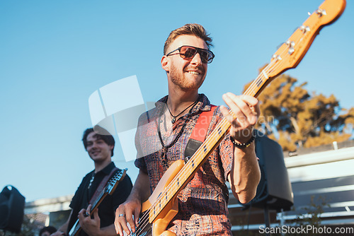 Image of Guitar, music and party with a band outdoor at a celebration playing a song as a musician or artist. Happy, fun and performance with a man guitarist holding an instrument to perform at a birthday