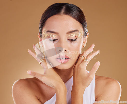 Image of Gold cosmetics, face glitter and woman with luxury eyeshadow, makeup product and studio skincare glow. Beauty, spa salon and aesthetic model girl with jewelry ring, accessories or vitiligo healthcare
